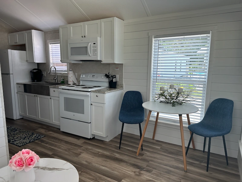 cooking area with stove, oven, refrigerator and other appliances with dining area